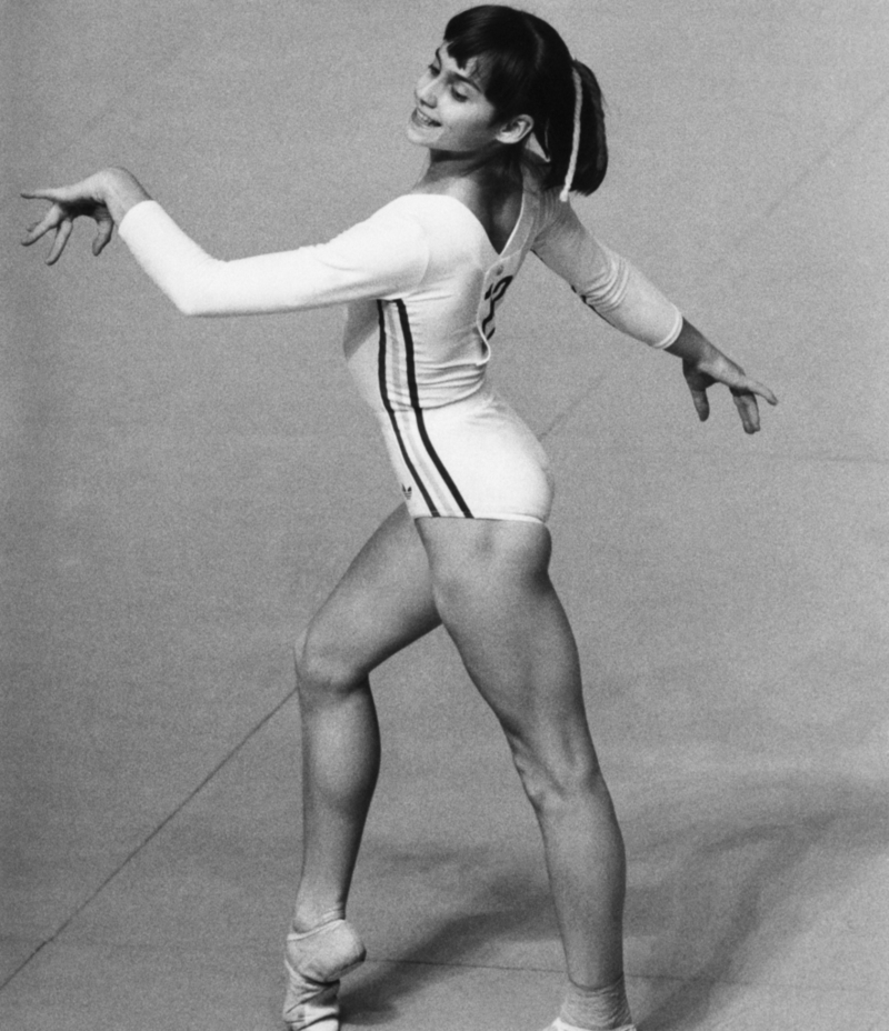 Eine strahlende  Nadia Comaneci, weltberühmte, rumänische Turnerin, performt als Bodenturnerin bei den olympischen Spielen im Sommer 1976 | Getty Images Photo by Bettmann 