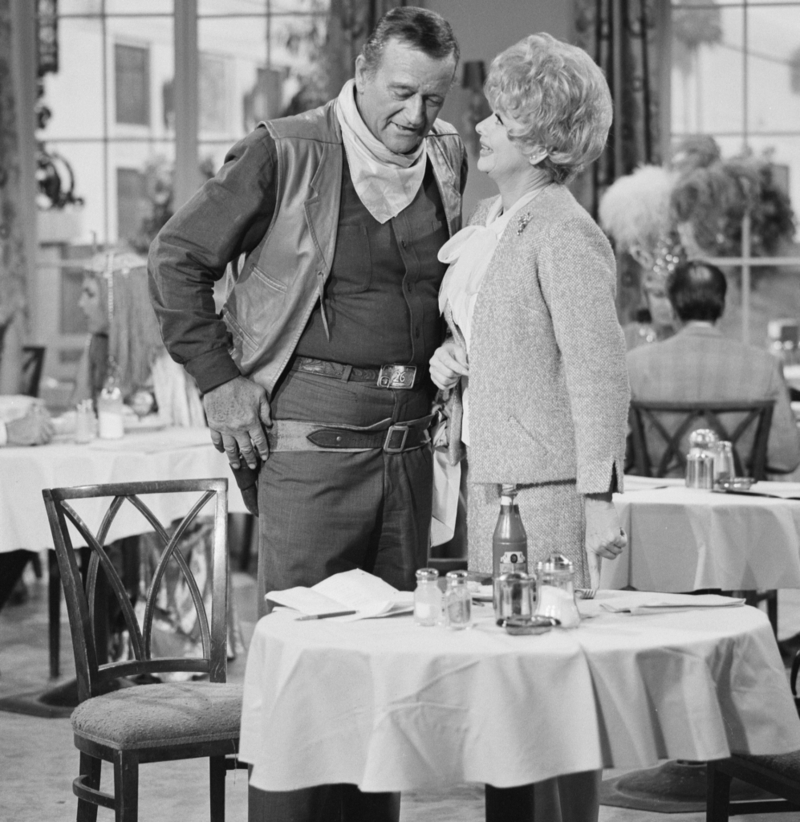 Und Action! Lucille Ball und John Wayne posieren während einer Szene aus ,,The Lucy Show” (1966) | Getty Images Photo by CBS Photo Archive